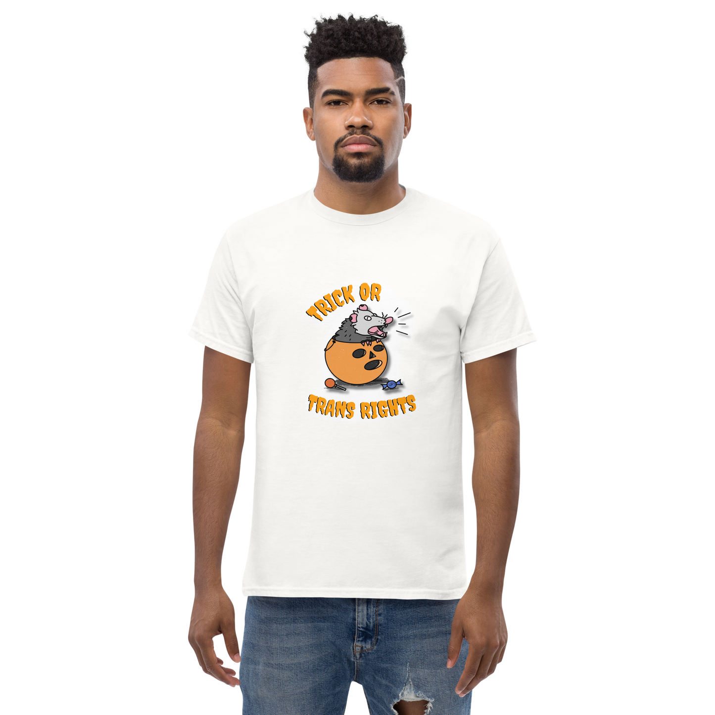 This design features a possum in an orange plastic candy bucket with the text "Trick or Transphobia" on a white t-shirt. This image is the shirt design on a standard sized model.