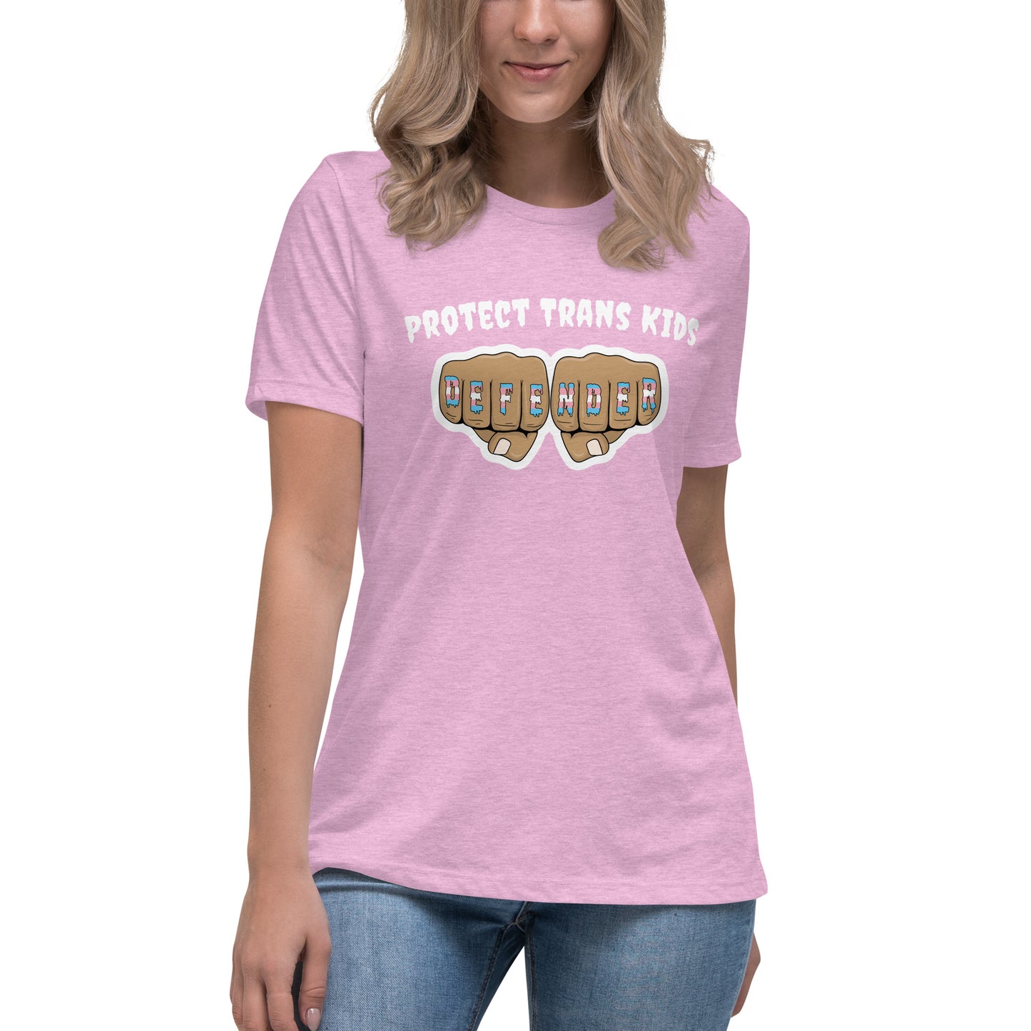 A standard, round neck, short sleeve t-shirt in light pink heather with the text "protect trans kids" in white lettering above an image of fists with "defender" written across the knuckles in blue,pink, and white. The shirt is on a white, straight sized model standing against a white background.