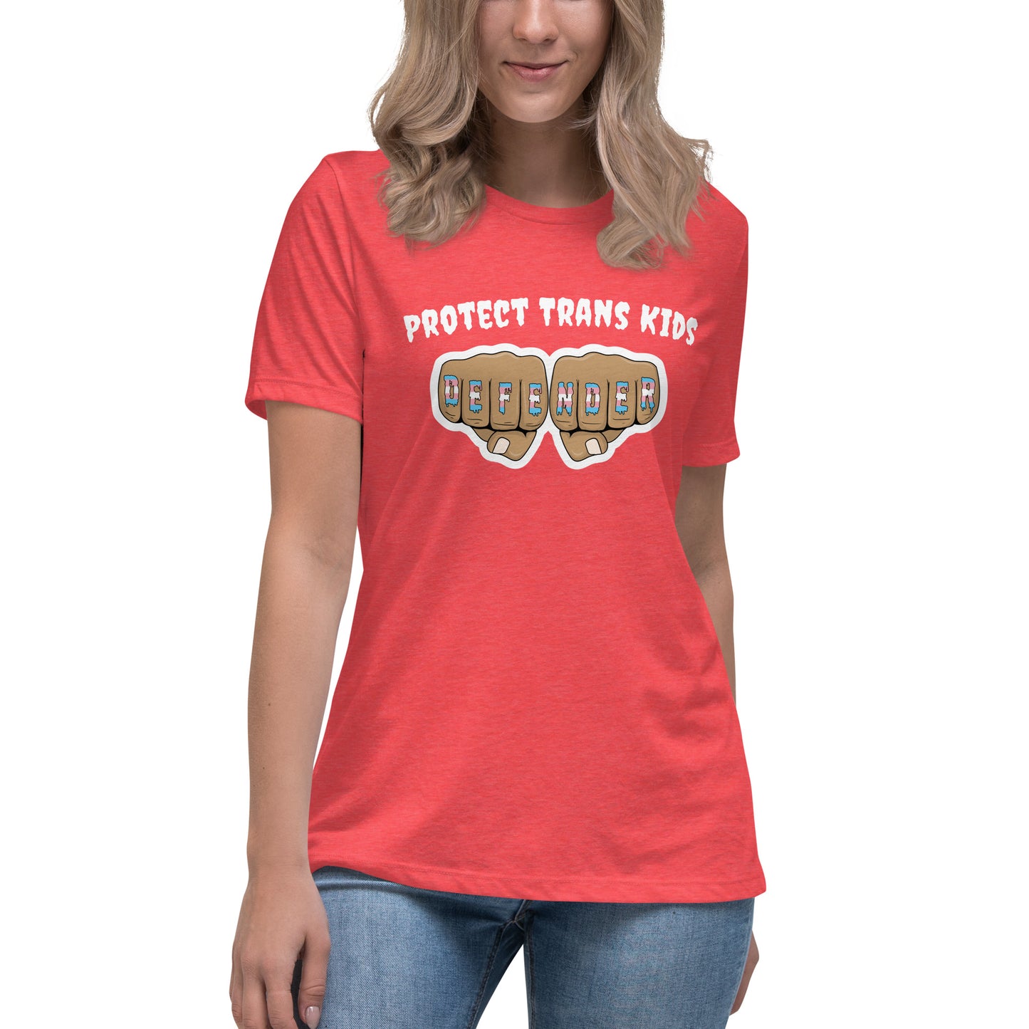 A standard, round neck, short sleeve t-shirt in peach with the text "protect trans kids" in white lettering above an image of fists with "defender" written across the knuckles in blue,pink, and white. The shirt is on a white, straight sized model standing against a white background.